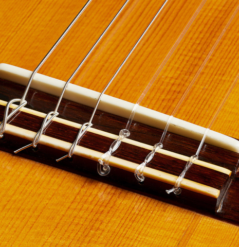 The bridge, tie-block and saddle of a 1928 Hermann Hauser I (ex Julian Bream) classical guitar made of spruce and CSA rosewood
