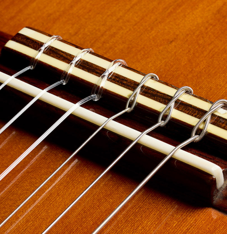The bridge, tie-block and saddle of a 1974 Marcelino Lopez classical guitar made of cedar and CSA rosewood