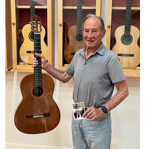 The original owner of the 1974 Marcelino Lopez in 2025, holding the guitar and 1974 photo