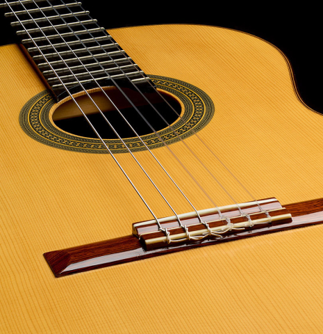 The soundboard and bridge of a 1996 Sergio Abreu classical guitar made of spruce and Indian rosewood