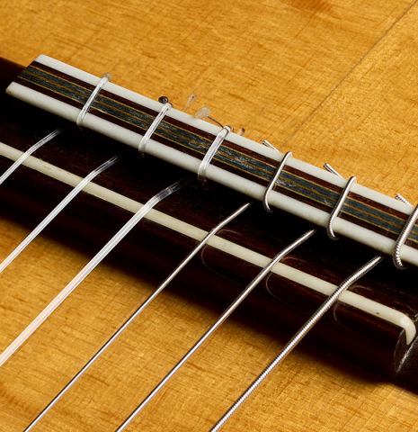 The bridge, tie-block and saddle of a 2000 Simon Ambridge classical guitar made with spruce and Indian rosewood
