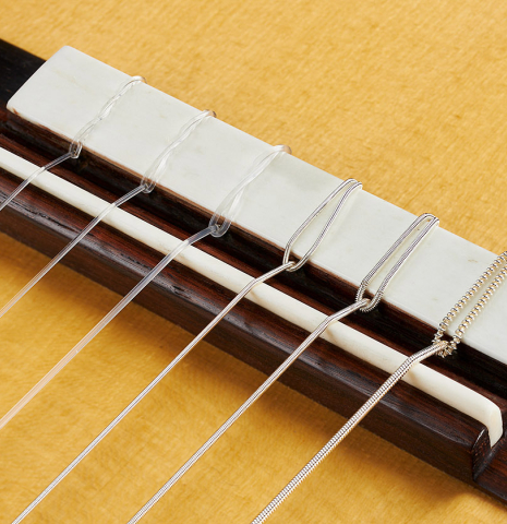 The bridge, tie-block and saddle of a 2024 Ariel Ameijenda "1885 Torres - SE 51" classical guitar made of spruce and CSA rosewood