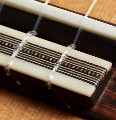 The bridge, tie-block and saddle of a 2024 Ariel Ameijenda classical guitar made of cedar and CSA rosewood