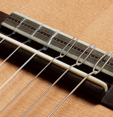 The bridge, tie-block and saddle of a 2025 Ariel Ameijenda classical guitar made of cedar and CSA rosewood