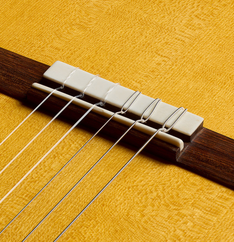 The bridge, tie-block and saddle of a 2026 Ariel Ameijenda "1885 Torres - SE 81" classical guitar made of spruce and cypress