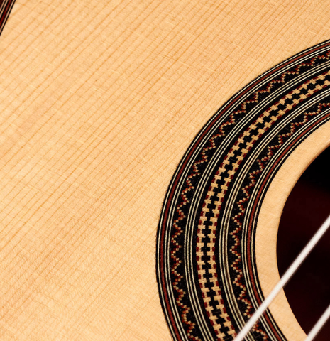 The soundboard and rosette of a 2022 Mario Aracama classical guitar made of spruce and African rosewood