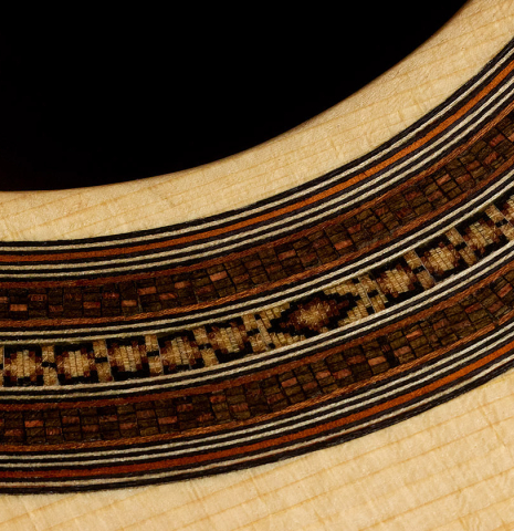 Closeup detail of the rosette mosaic of a 2026 Mario Aracama classical guitar made of spruce and African rosewood