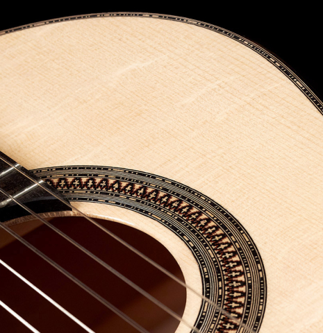 The soundboard and rosette of a 2023 Mario Aracama classical guitar made of spruce and maple.