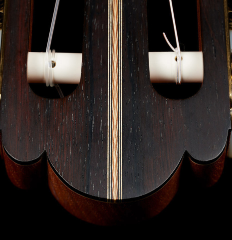 The headstock veneer of a 2021 Kevin Aram "Carmen 640" classical guitar made of spruce and Indian rosewood