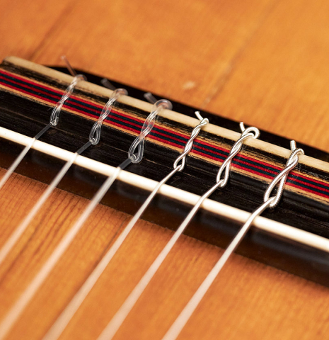 The bridge, saddle and tie-block of a 1903 Vicente Arias classical guitar made with spruce and CSA rosewood