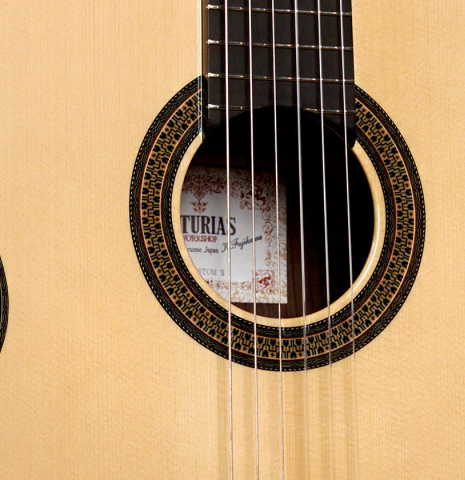 The soundboard and rosette of an Asturias &quot;Custom S&quot; classical guitar made of spruce and Indian rosewood