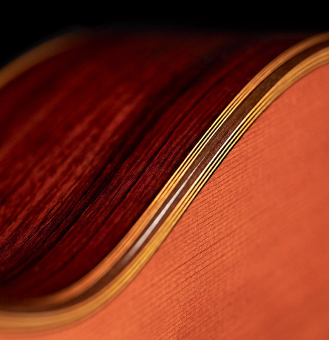 Detail of the binding and purfling connecting the sides to the top of a 2014 Angel Benito Aguado classical guitar made of cedar and Indian rosewood.