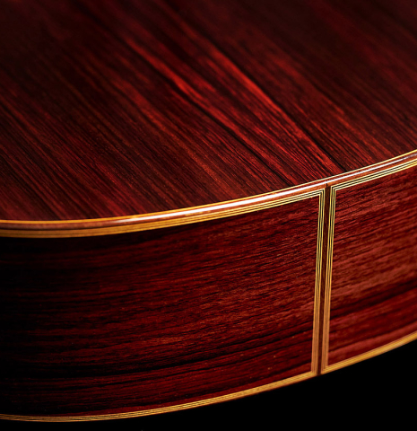 The back and sides at the foot of a 2014 Angel Benito Aguado classical guitar made of cedar and Indian rosewood.