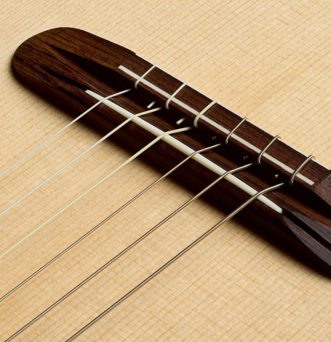 The bridge, tie-block and saddle of a 2011 Angel Benito Aguado "Romantic" classical guitar made of spruce and maple
