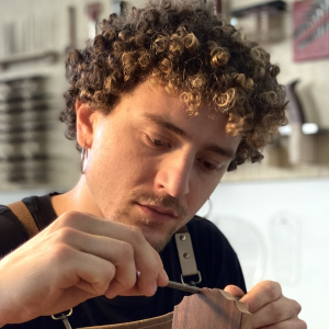 Guitar maker Francesco Baccaglion shaping a guitar headstock in his Turin workshop
