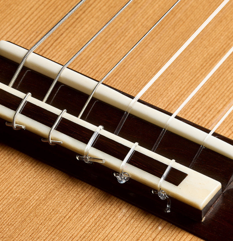 The bridge, saddle and tie-block of a 2025 Henrik Ballowitz classical guitar made of cedar and African Blackwood