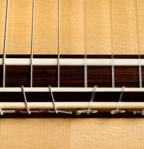 The bridge, tie-block and saddle of a 2026 Henrik Ballowitz classical guitar made of spruce and Indian rosewood