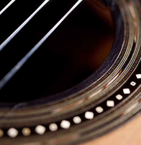 A close-up of the rosette of a The headstock and tuners of a 2020 Kris Barnett classical guitar made with cedar and African rosewood