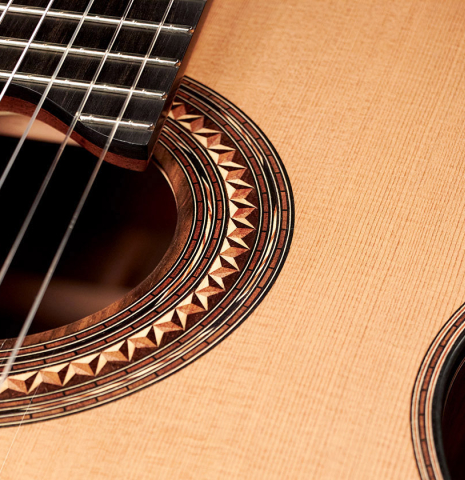 A close-up of the rosette of a 2023 Kris Barnett classical guitar made with cedar and exotic ebony