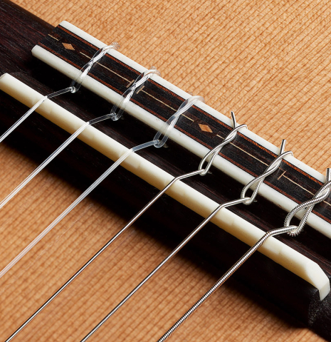 The bridge, tie-block and saddle of a 2025 Kris Barnett classical guitar made of cedar and exotic ebony