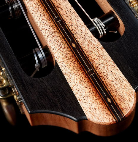 The front headstock veneer of a 2025 Kris Barnett classical guitar made of cedar and exotic ebony