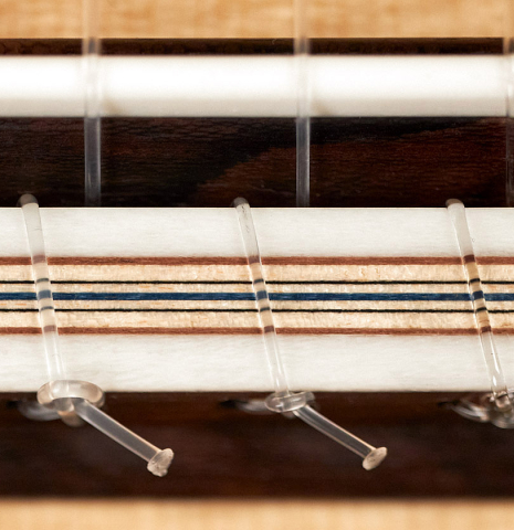The bridge, tie-block and saddle of a 2023 Marco Bortolozzo classical guitar made with spruce and ziricote