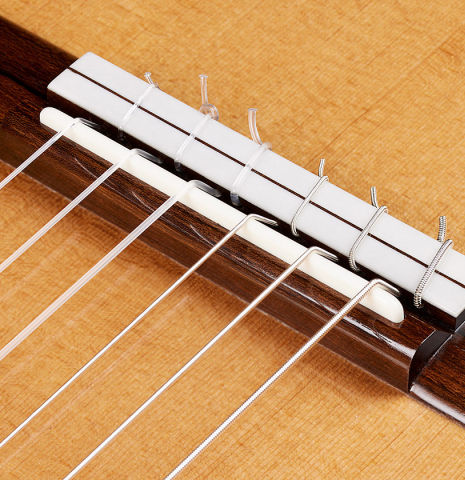 The bridge, tie-block and saddle of a 2024 Marco Bortolozzo classical guitar made of spruce and ziricote