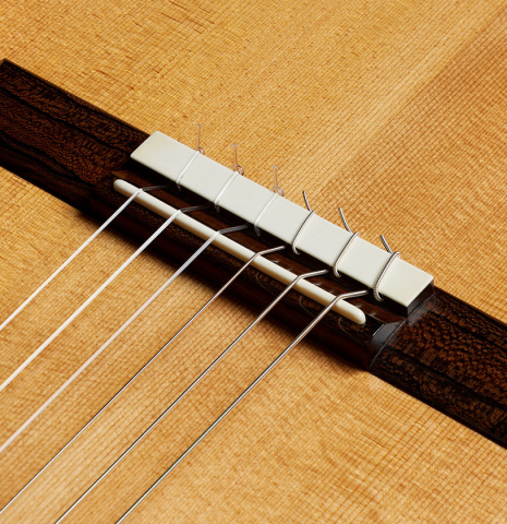 The bridge, tie-block and saddle of a 2024 Marco Bortolozzo classical guitar made of spruce and ziricote