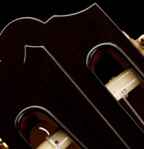 The carved headstock veneer of a 2024 Mario Grimaldi "1963 Daniel Friederich, ex Ida Presti" classical guitar made of spruce and African rosewood
