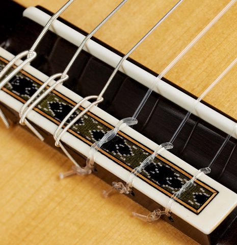 The bridge, tie-block and saddle of a 2024 Mario Grimaldi "1963 Daniel Friederich, ex Ida Presti" classical guitar made of spruce and African rosewood