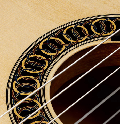 Closeup of the rosette of a 2025 Marco Bortolozzo classical guitar made of spruce and pomellè mahogany