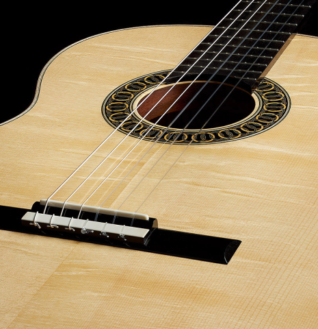 The soundboard of a 2025 Marco Bortolozzo classical guitar made of spruce and pomellè mahogany