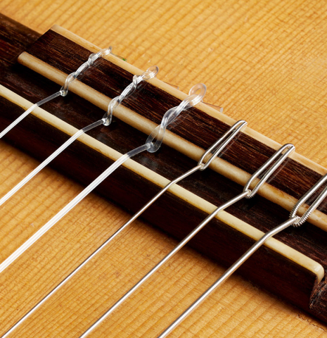 The bridge, tie-block and saddle of a 1947 Marcelo Barbero w/pegs classical guitar made of spruce and CSA rosewood