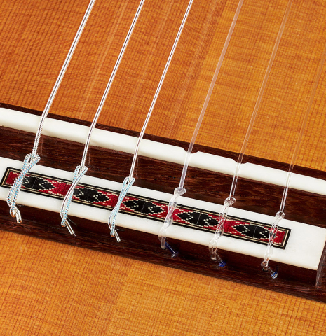 The bridge, tie-block and compensated saddle of a 2024 Michel Belair "Hommage a Daniel Friederich" classical guitar made of cedar and Indian rosewood