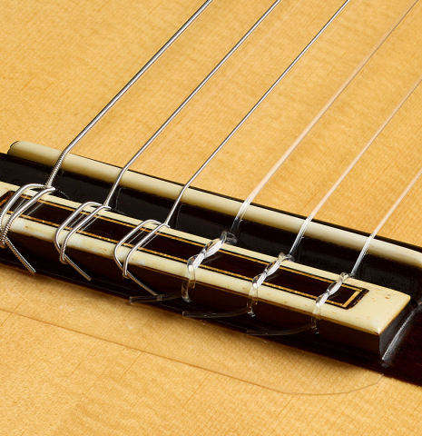The bridge, tie-block and saddle of a 1999 Jose Lopez Bellido classical guitar made of spruce and CSA rosewood