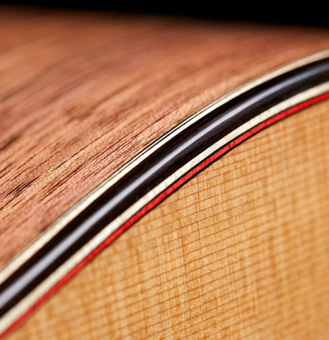 The top binding and purfling of a 2016 Tobias Berg classical guitar made of cedar and walnut