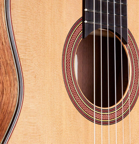 The soundboard and rosette of a 2016 Tobias Berg classical guitar made of cedar and walnut
