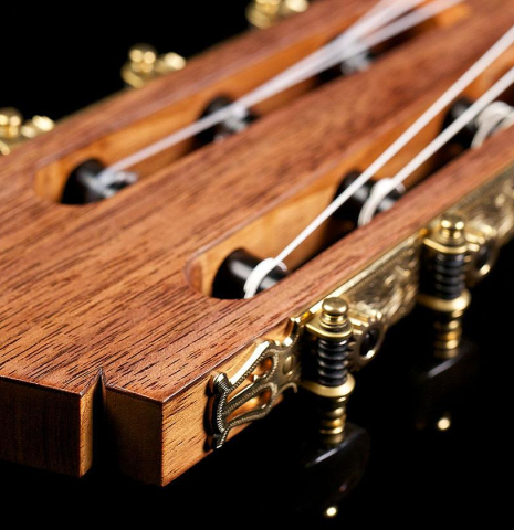 The headstock veneer and tuning machines of a 2016 Tobias Berg classical guitar made of cedar and walnut