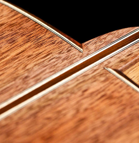 The heel, back binding and purfling of a 2016 Tobias Berg classical guitar made of cedar and walnut