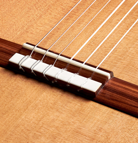 The bridge and tie block of a 2022 Tobias Berg classical guitar made of cedar and European walnut.