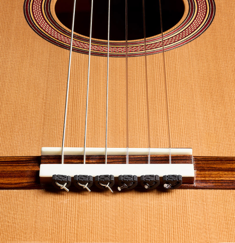 The bridge, tie-block and saddle of a 2025 Tobias Berg classical guitar made of cedar and walnut