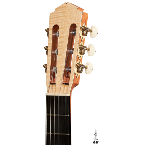 The headstock of a 2023 Tobias Berg classical guitar made of spruce and flamed maple on a white background.
