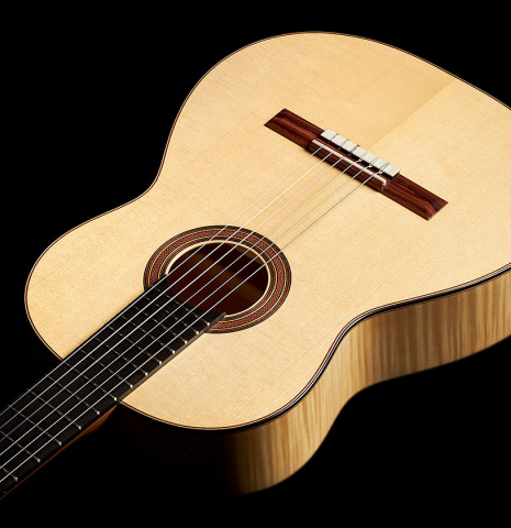 The soundboard and sides of a 2023 Tobias Berg classical guitar made of spruce and flamed maple.
