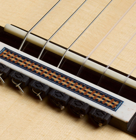 The bridge, tie-block and saddle of a 2026 Tobias Berg "Bouchet" classical guitar made of spruce and Indian rosewood