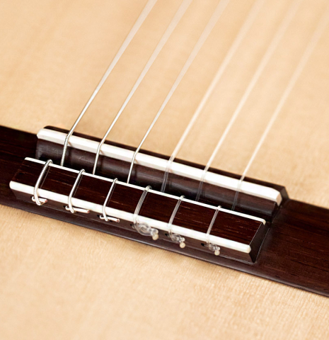 The bridge of a 2023 Edmund Blöchinger "Llobet" classical guitar made with spruce top and CSA rosewood back and sides.
