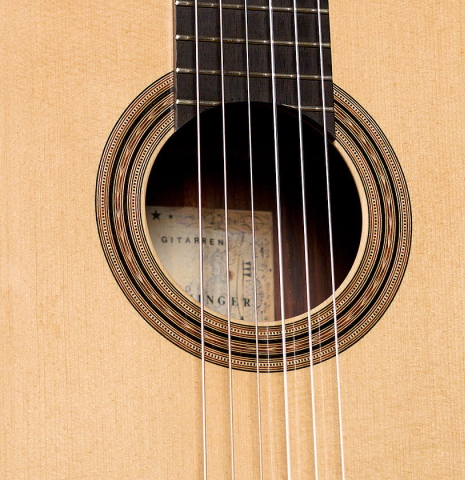 This is a soundboard and rosette of a 2000 Edmund Blochinger classical guitar made with spruce and csa rosewood on a black background