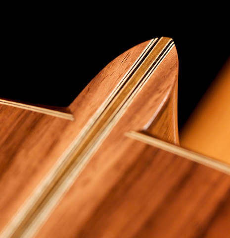 This is a heel of a 2000 Edmund Blochinger classical guitar made with spruce and csa rosewood on a black background