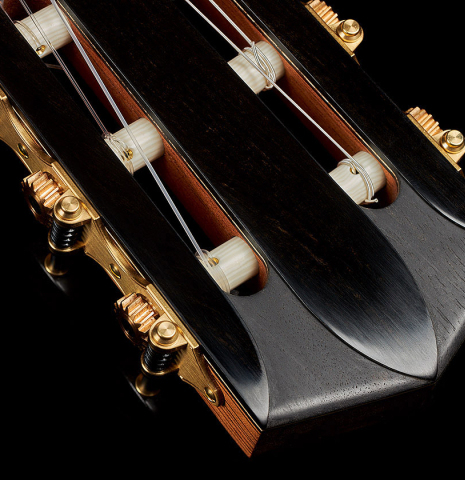 The carved headstock and tuning machines of a 2023 Elias Bonet classical guitar made of cedar and green ebony