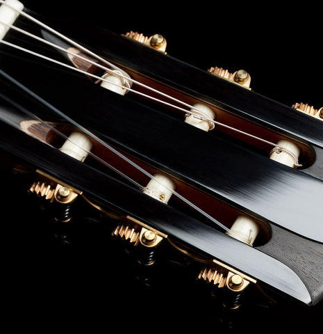 The headstock with carved veneer and tuning machines of a 2025 Elias Bonet classical guitar made of cedar and green ebony