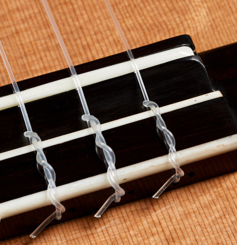 The bridge, tie-block and saddle of a 2024 Elias Bonet classical guitar made of cedar and African rosewood